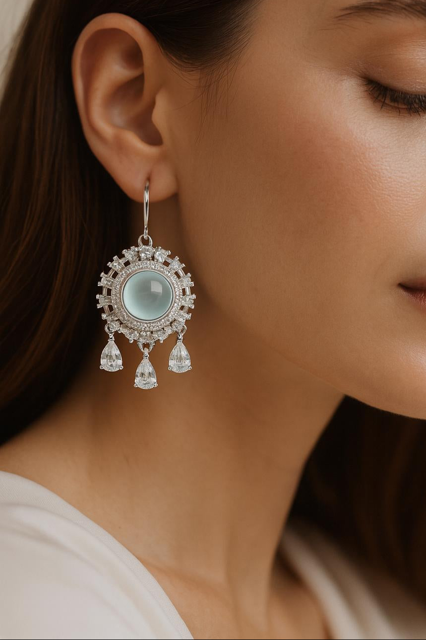 Close-up of a woman wearing elegant earrings with a neutral background