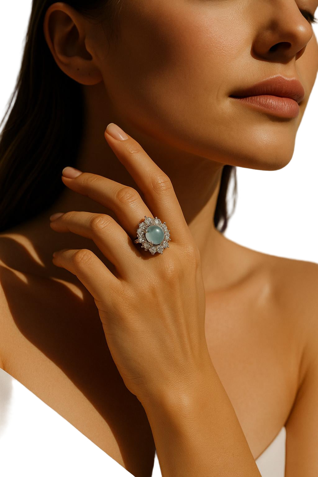 Close-up of a woman's hand wearing an elegant ring with a large gemstone on a white background