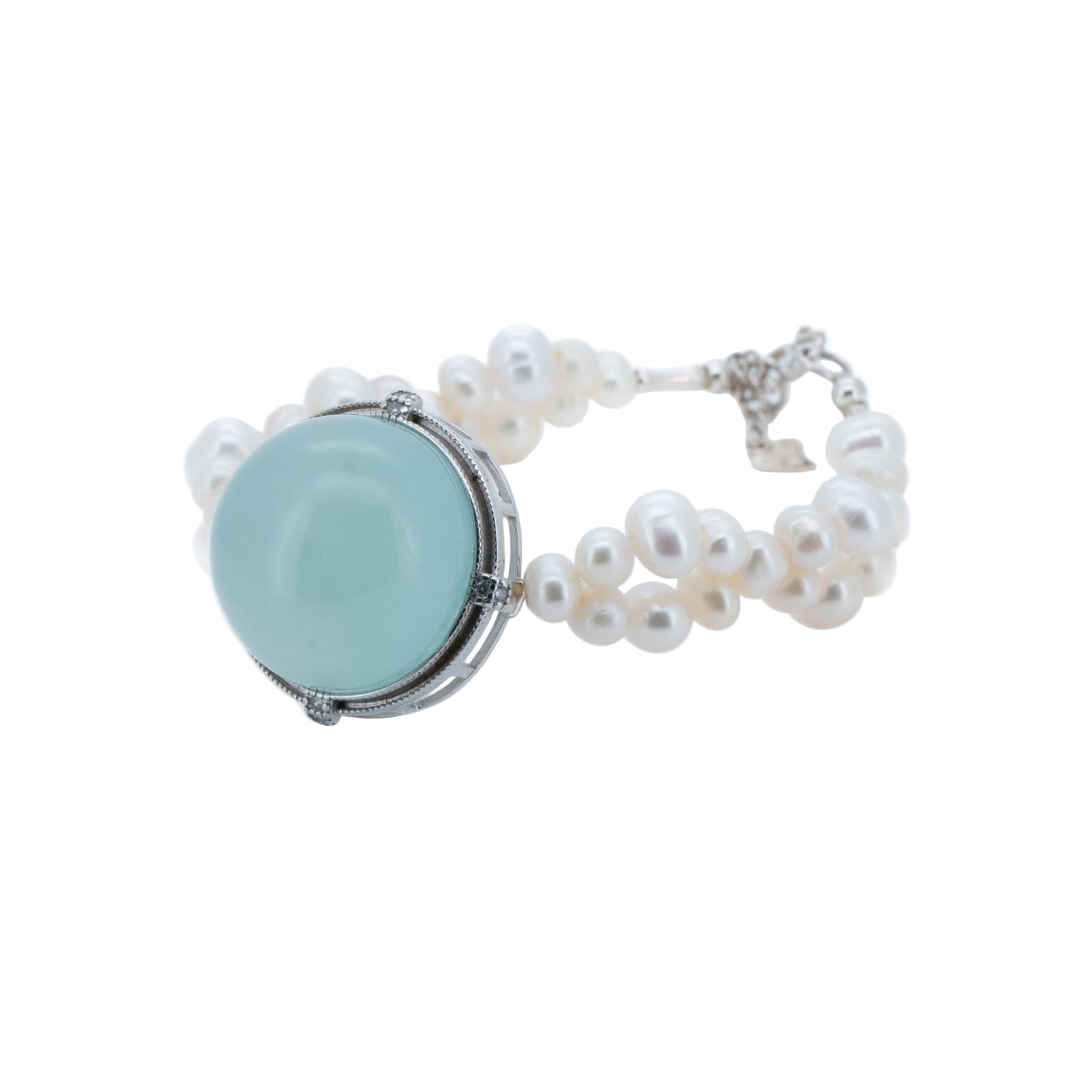 Bracelet with light blue circular stone and white pearls on a white background